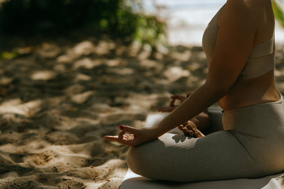 woman meditating on the beach